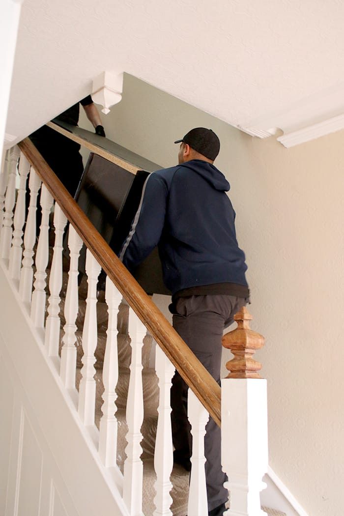 Removals Man Carrying Furniture Down Stairs - Manchester Removals & Storage - Manchester Removals & Storage